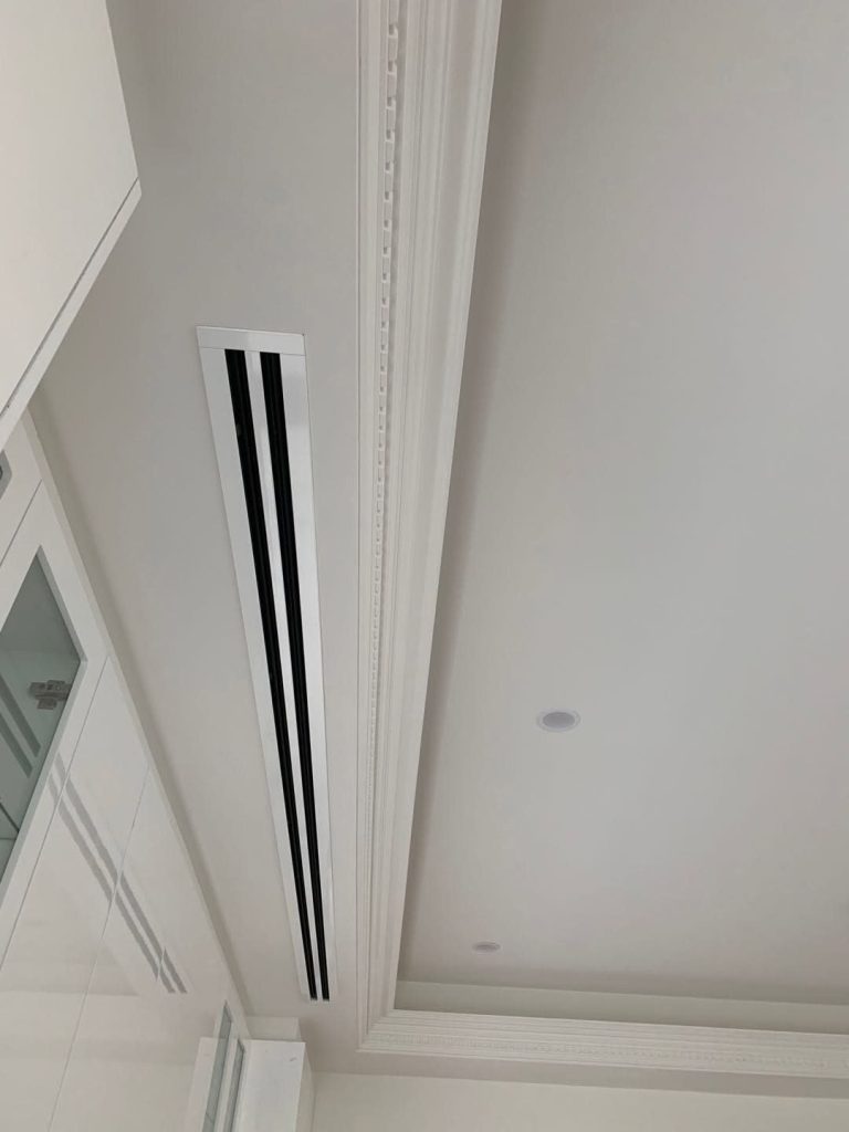 Concealed ducted air conditioning with a slot diffuser beside ornate cornice in a designer Melbourne home